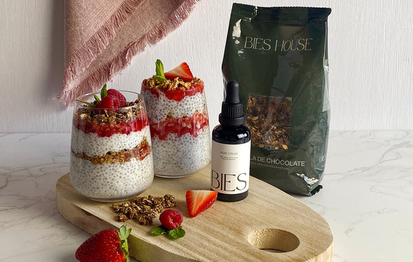 Pudín de chía con Granola de Chocolate BIES y frutos rojos en vaso de cristal junto a Stevia BIES y bolsa de Granola de Chocolate BIES